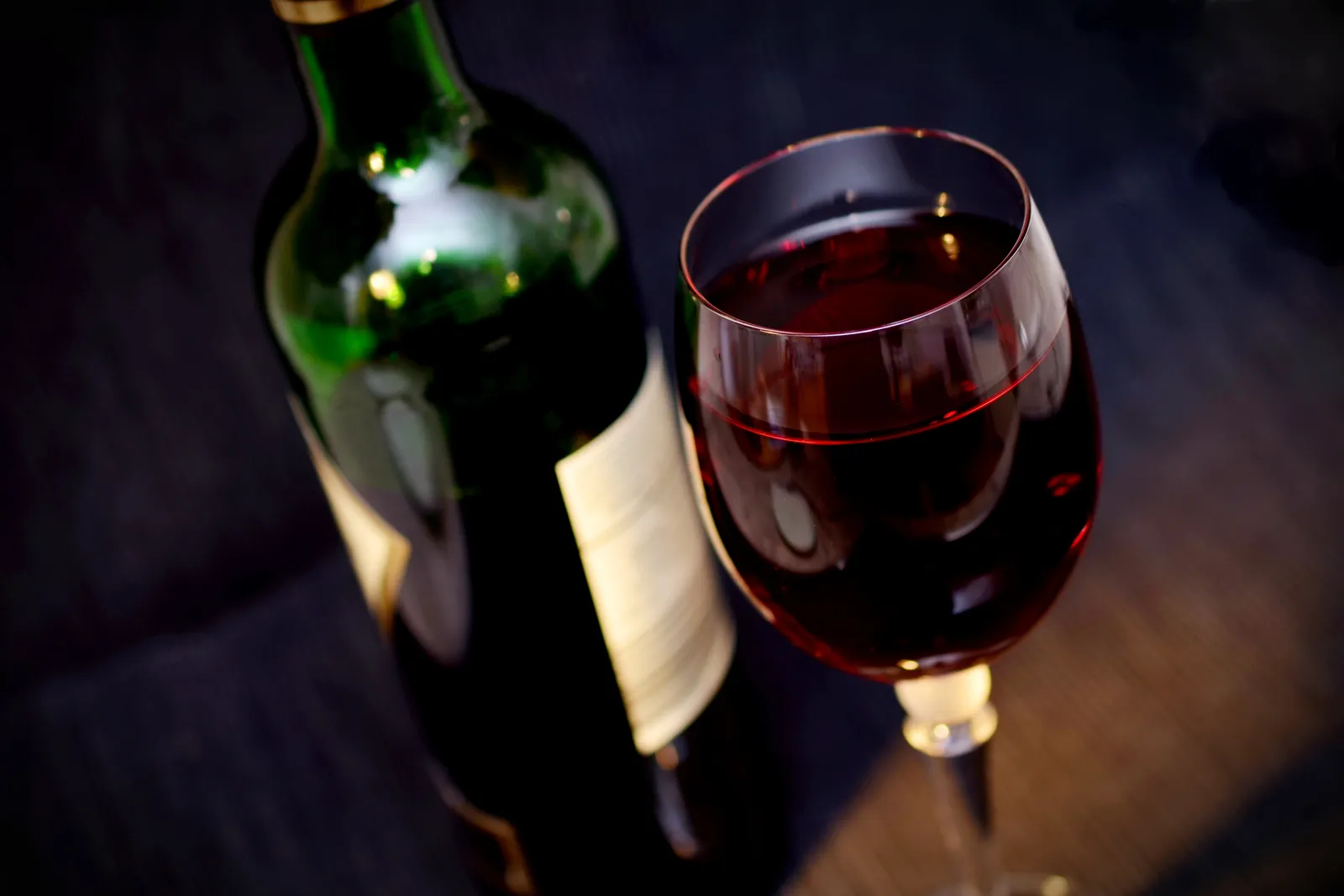 A bottle and a glass of red wine