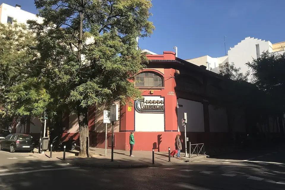 The red-brick Mercado de Vallehermoso building seen across the street under a blue sky