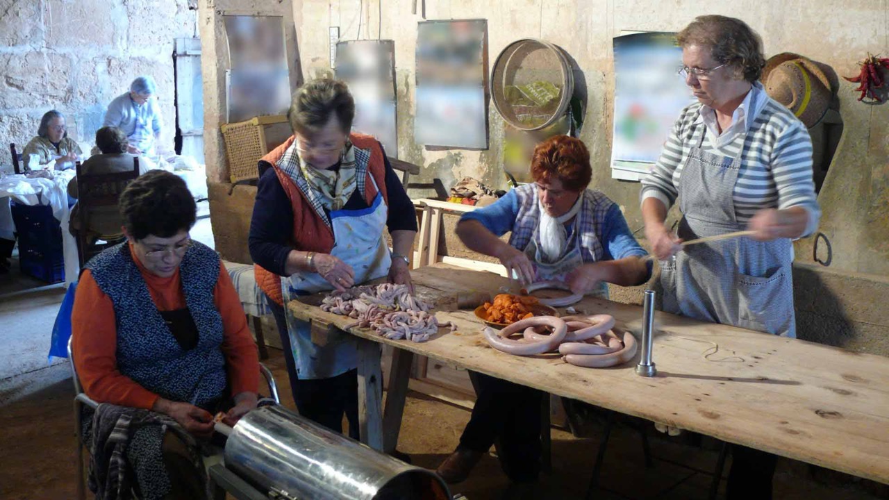 Women in Campos, Mallorca making sobrassada by hand during a traditional matances session