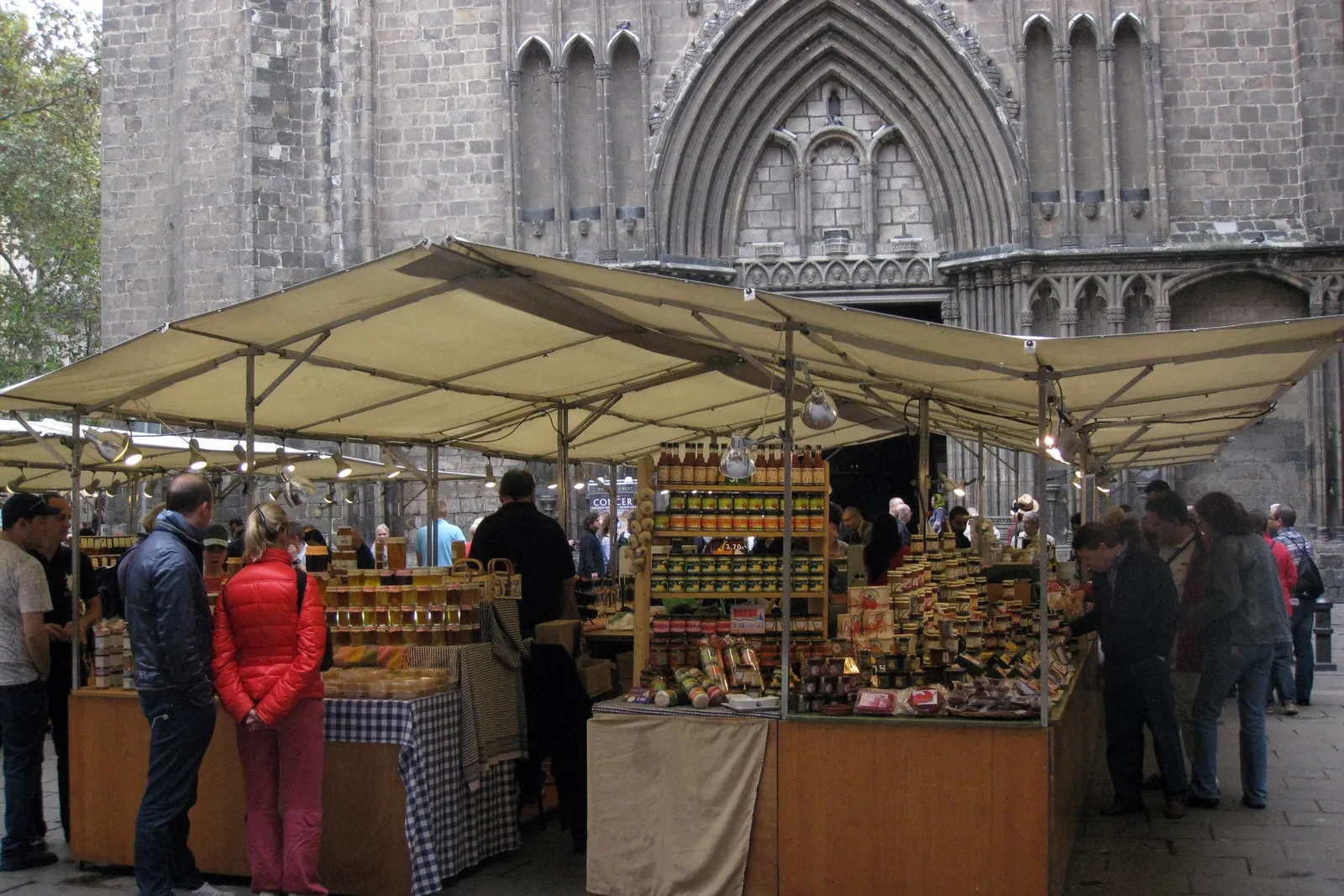Artisan food stalls with jars of honey and preserves in front of Santa Maria del Pi