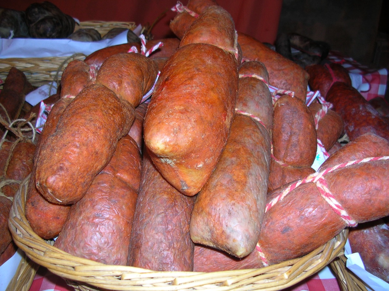 A wicker basket piled with cured Balearic sobrassada sausages tied with string