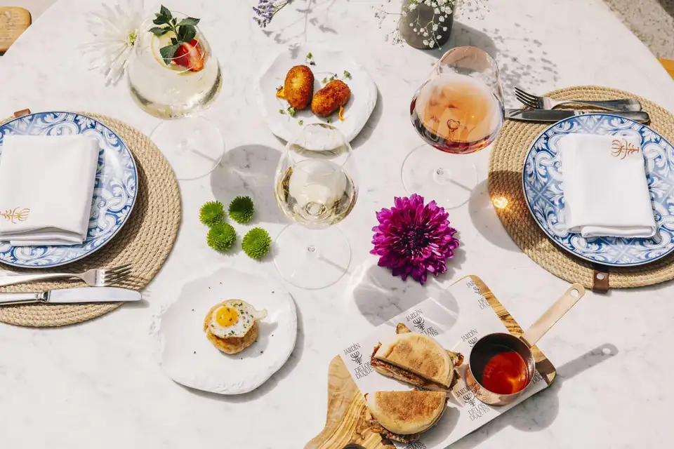 Overhead view of a hotel table set with small tapas plates, wine glasses and blue-and-white china