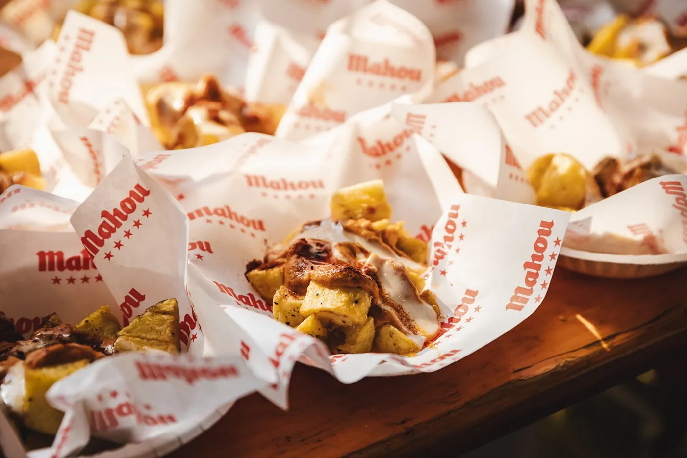 Patatas bravas served in Mahou-branded paper at Poble Espanyol