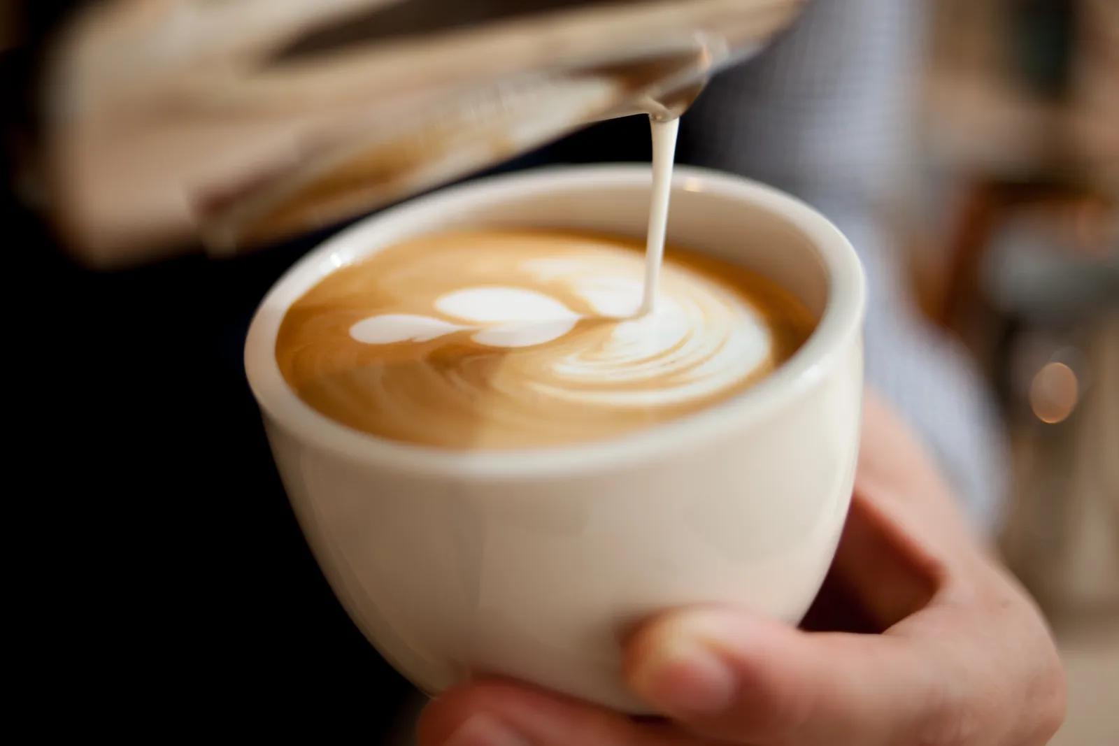 Milk being poured into a cappuccino to make latte art