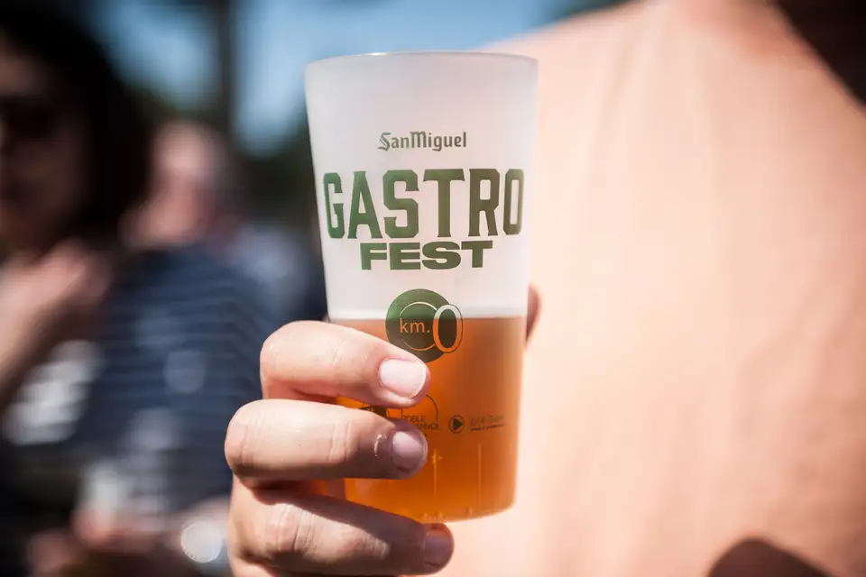 A hand holding a San Miguel Gastro Fest cup of beer