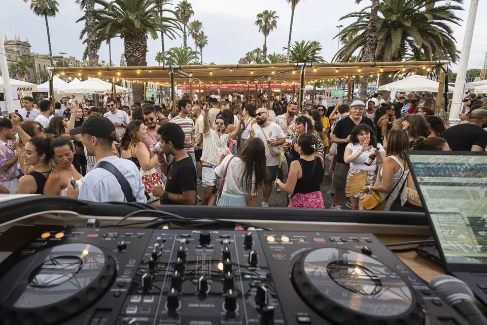 Crowd gathered at Port Olimpic during Vermut & Soul, palm trees and seafront in golden afternoon light