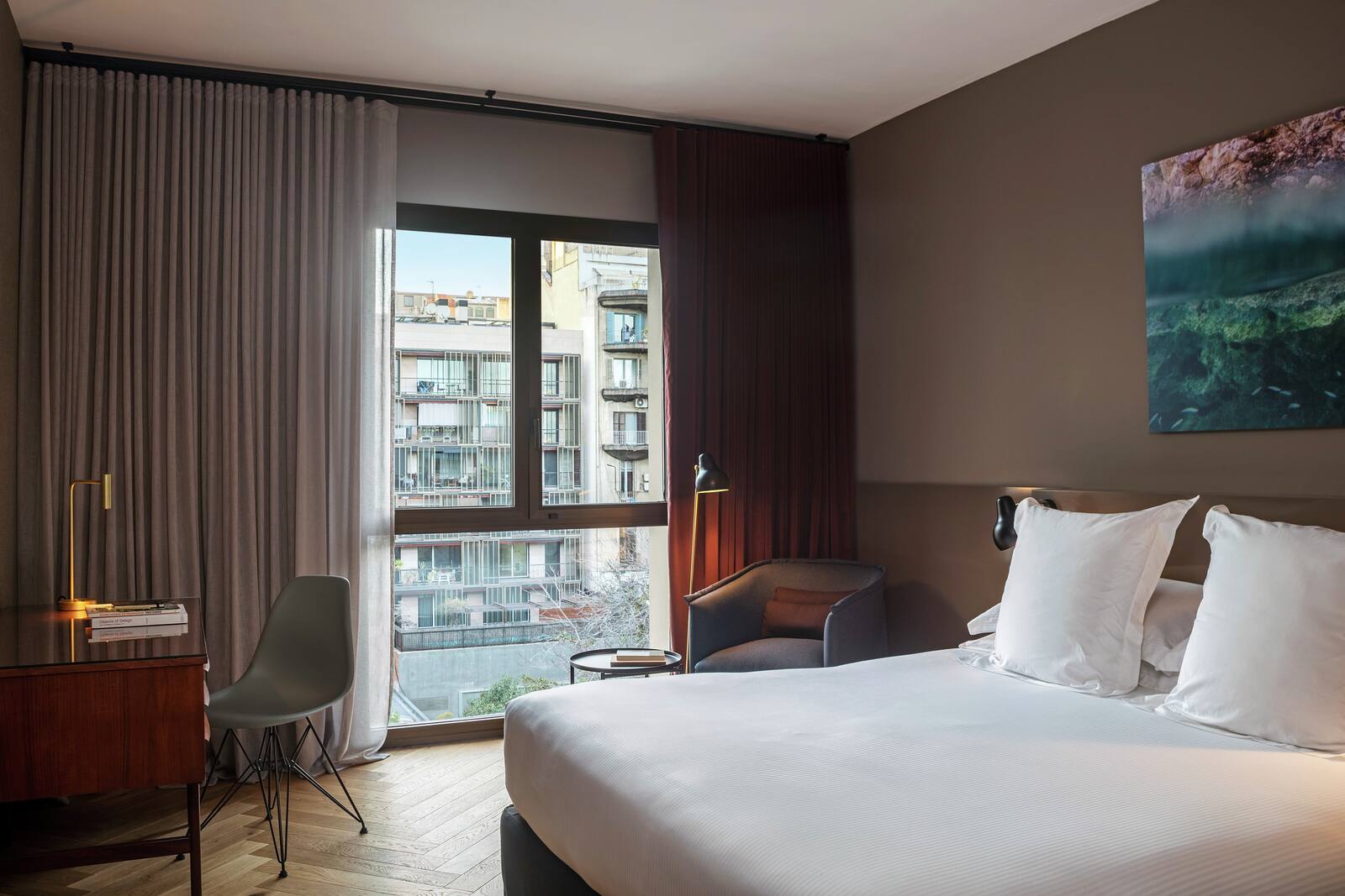 Guest room with a king bed, an armchair and a city-facing window