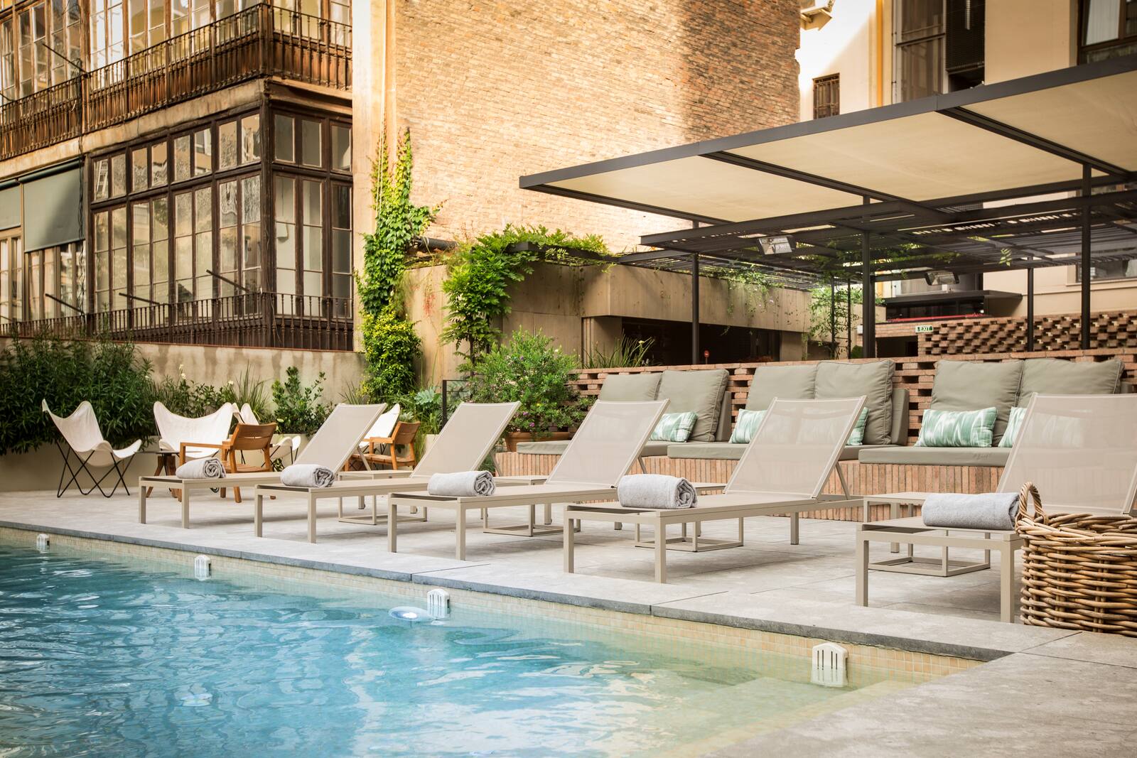 Courtyard pool deck with loungers surrounded by period Barcelona buildings