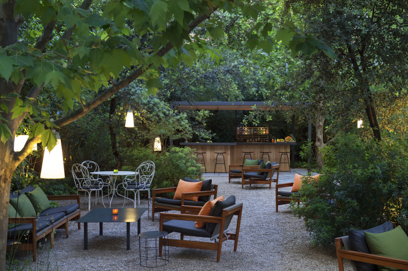 Outdoor garden lounge and bar under trees with string lighting