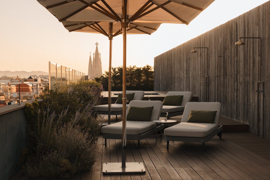 Rooftop terrace with sun loungers and the Sagrada Família in the distance