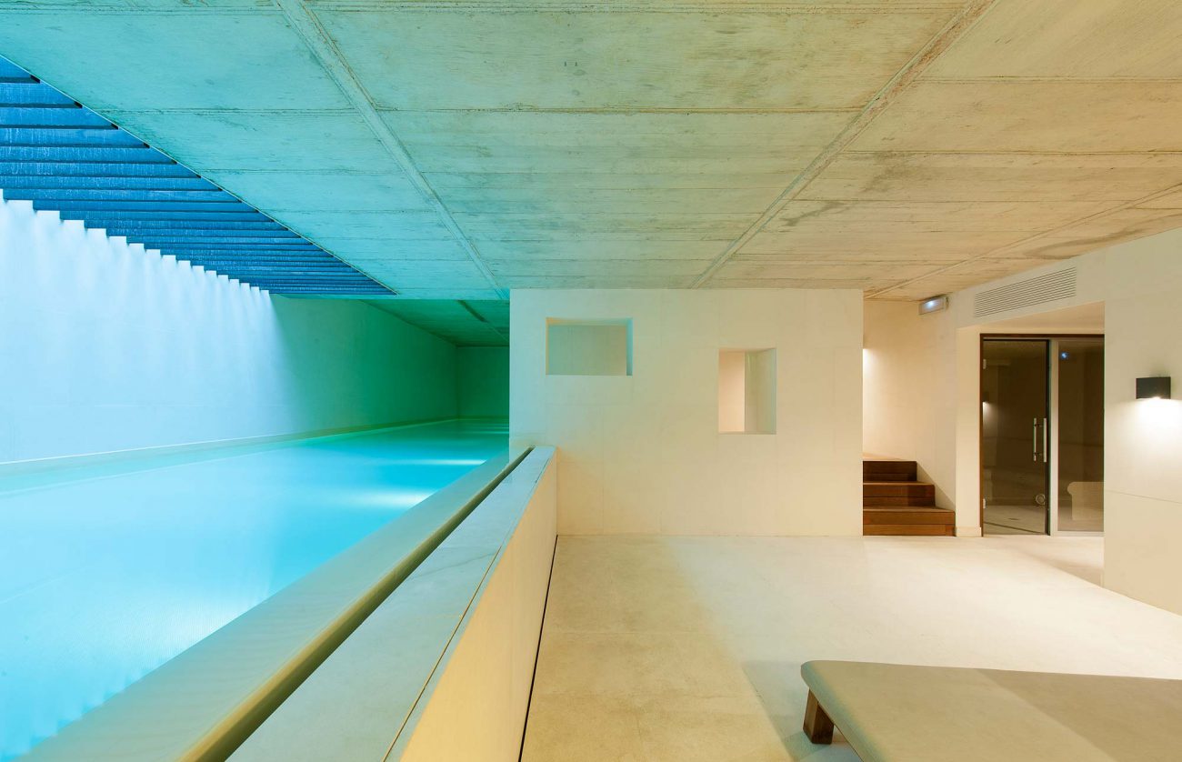 Indoor wellness pool with sculptural concrete architecture