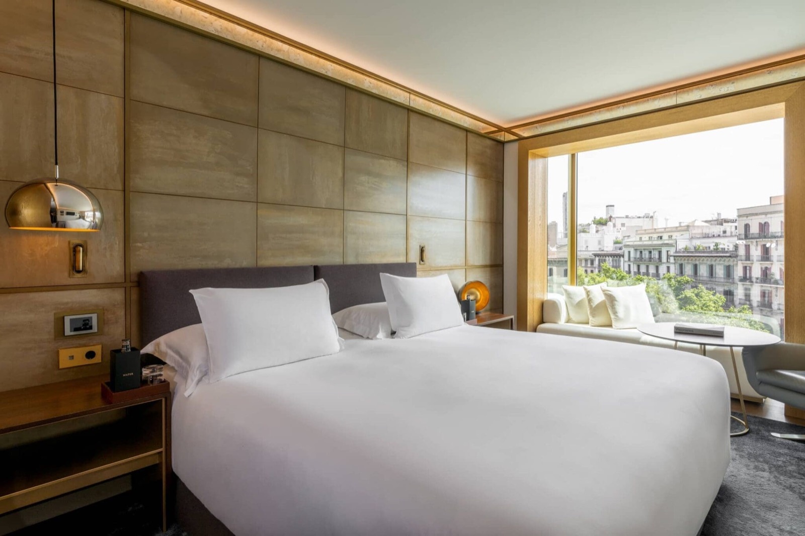 Guest room with gold-toned wall paneling and a city-view window seat