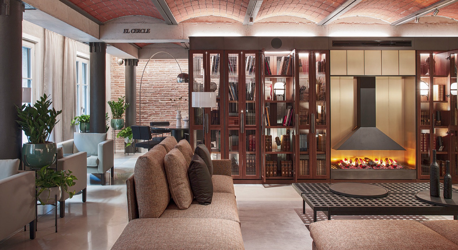 Hotel lounge library with glass-front bookcases and a fireplace