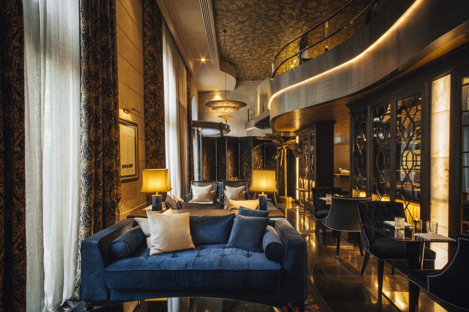 Hotel Bagués lounge bar with a blue velvet sofa and a gilded balcony
