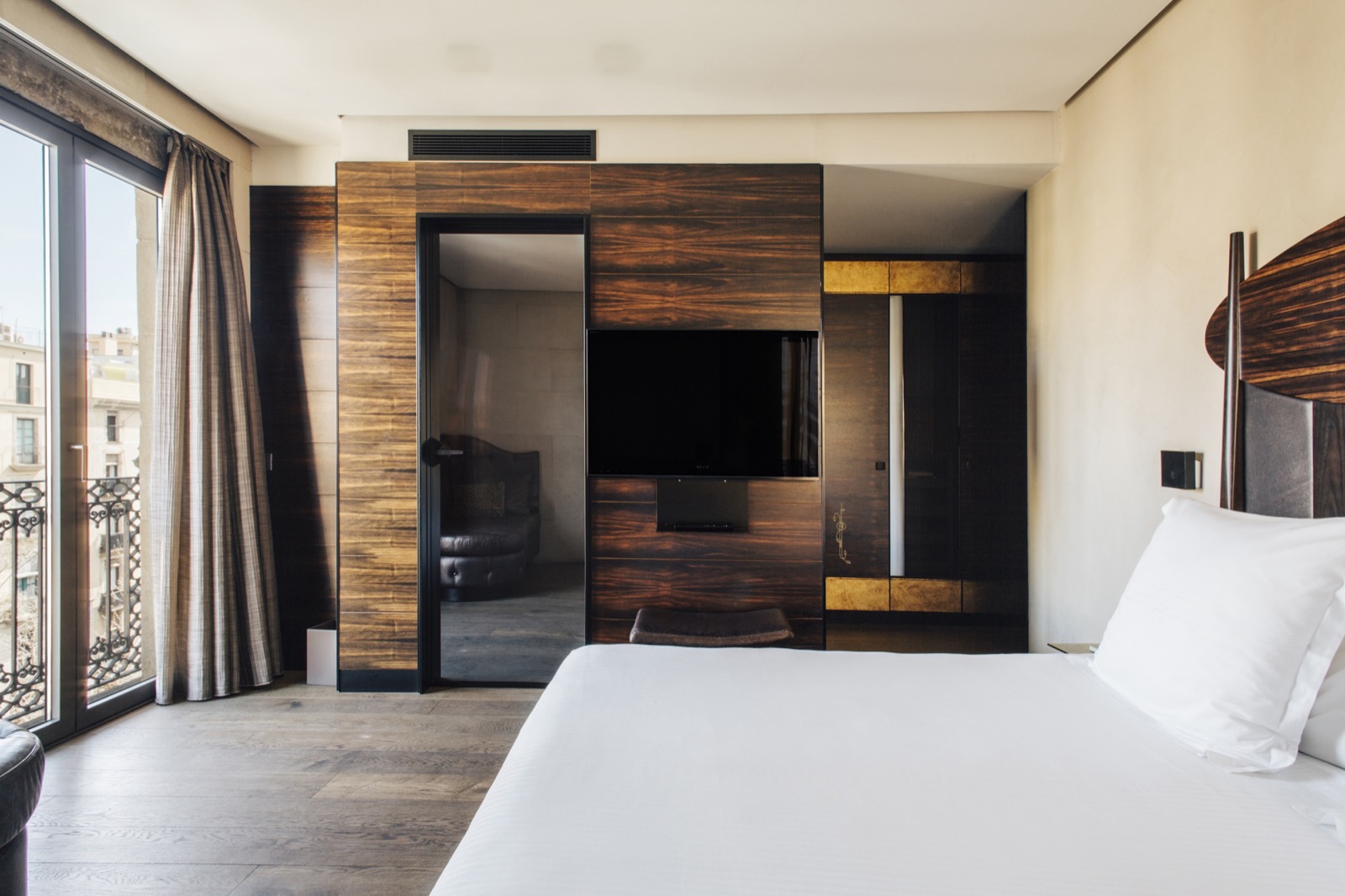 Deluxe room with dark wood paneling, a king bed and a balcony view