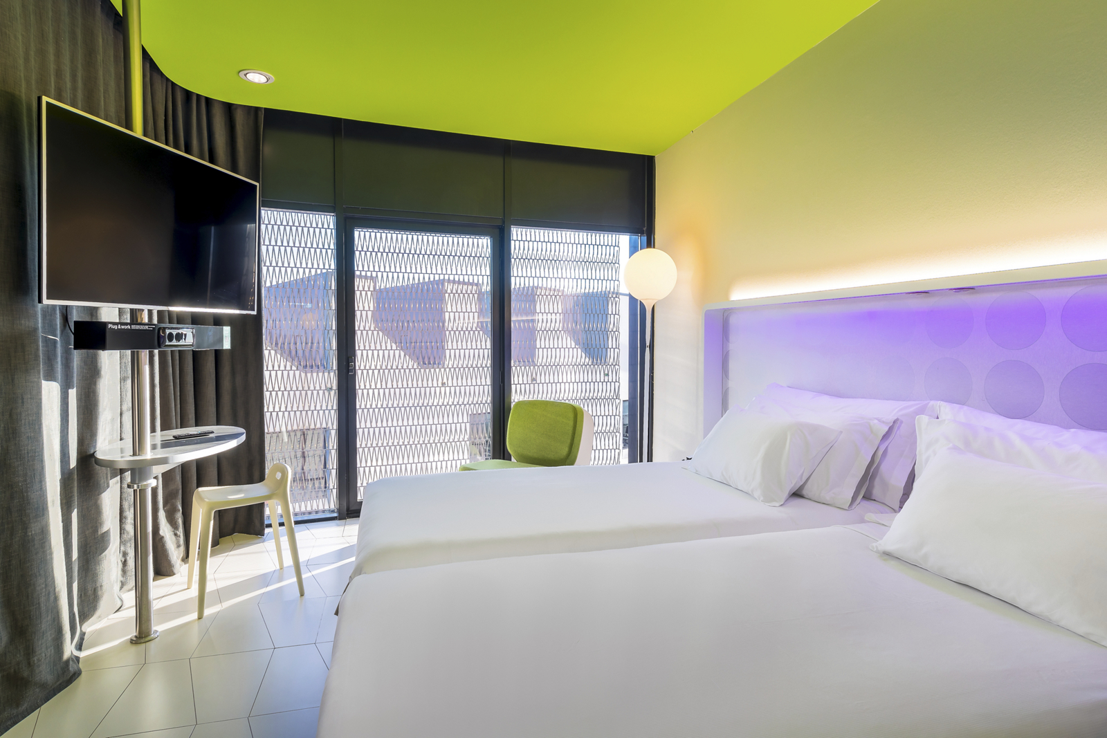 Superior room with twin beds, a lime-green ceiling accent and a city view