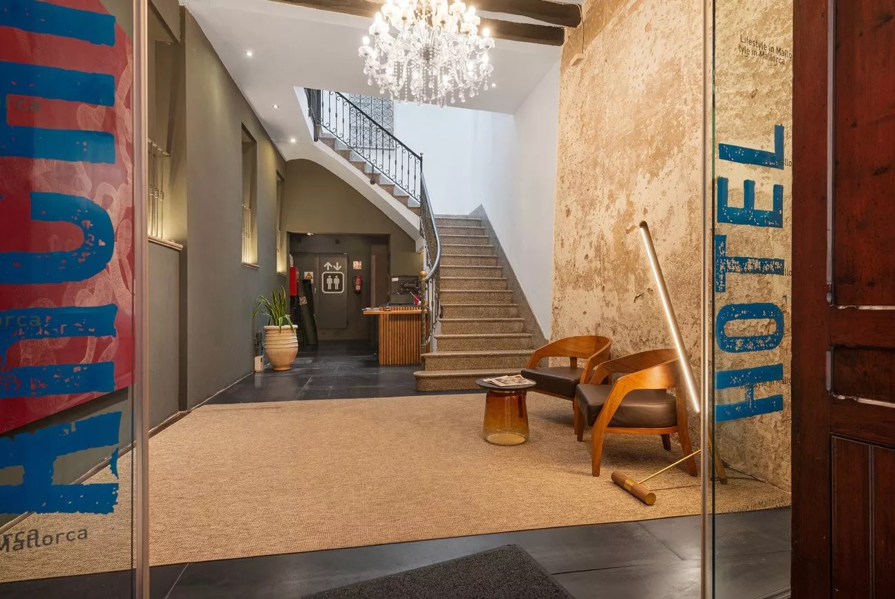 Old Town lobby with a curved stone staircase, wrought-iron railing and exposed stone wall