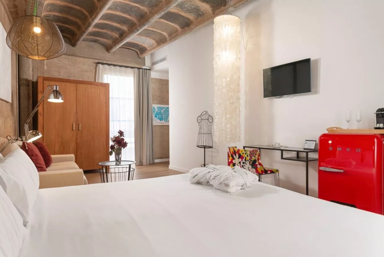 Guest room with a red Smeg mini-fridge, wall-mounted TV and wooden wardrobe