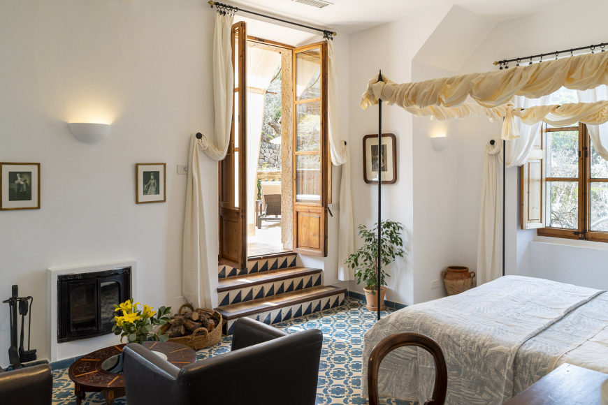 Deluxe room with a four-poster bed, working fireplace and traditional Mallorcan floor tiles