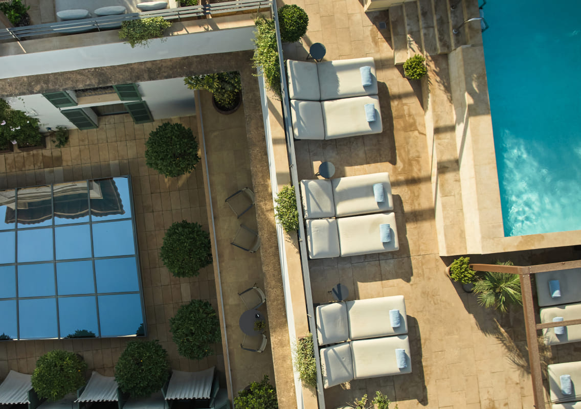 Aerial view of the rooftop pool and sun loungers at Can Alomar