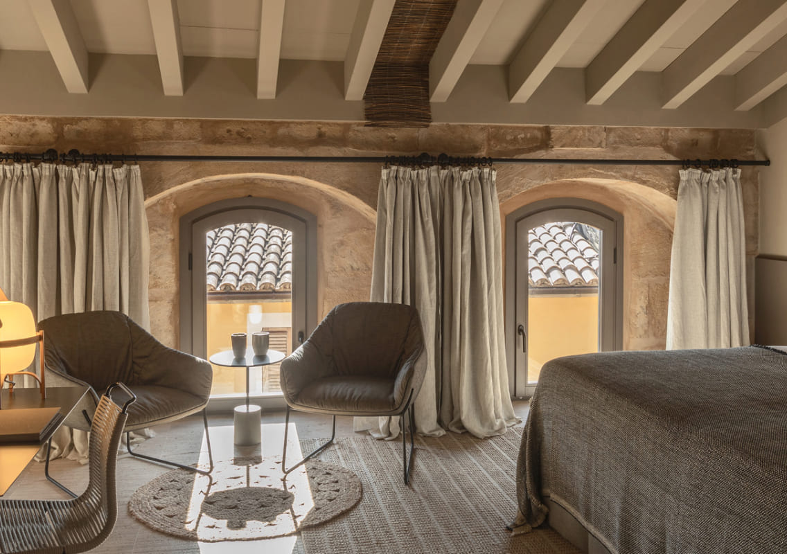 Bedroom suite at Can Auli Luxury Retreat with stone arched windows