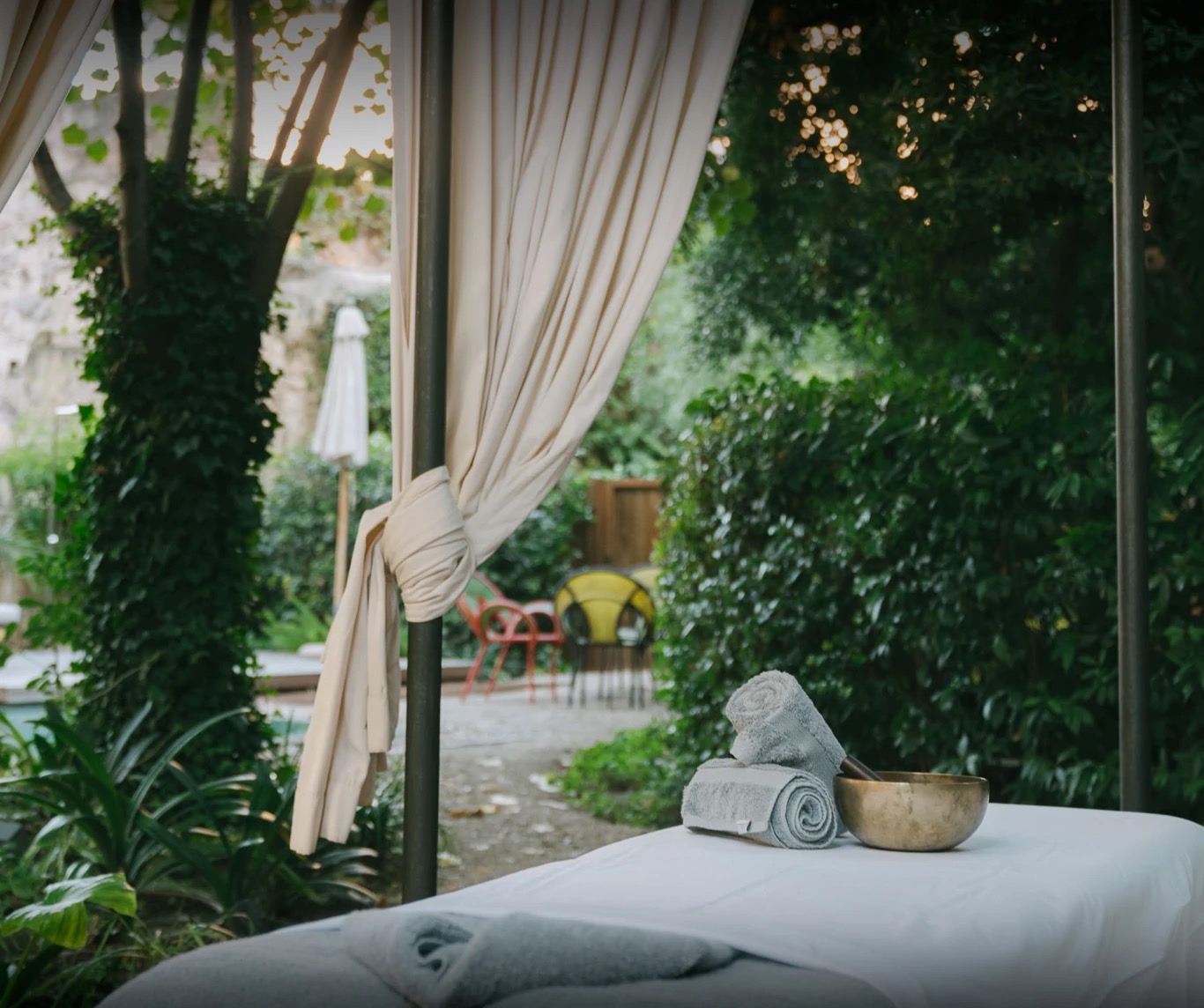 Outdoor spa treatment bed with rolled towels set in the garden