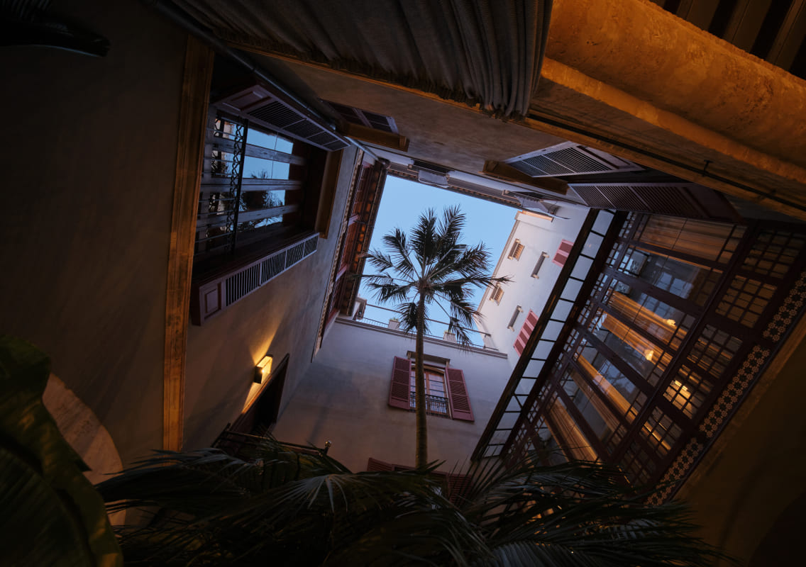 View up through the courtyard to the palacete's upper floors and shuttered windows