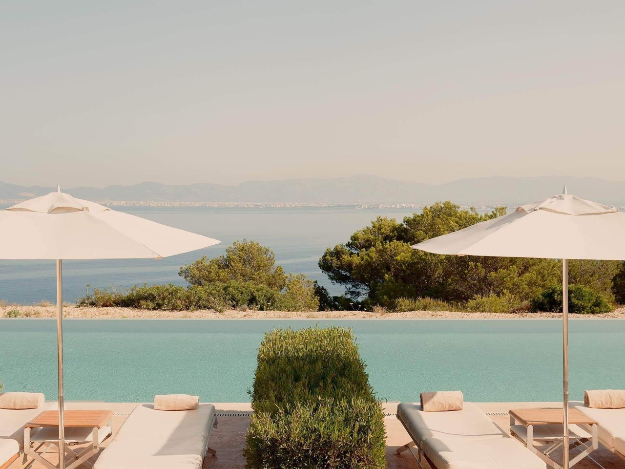 Infinity pool at Cap Rocat overlooking the Bay of Palma with sun loungers and umbrellas