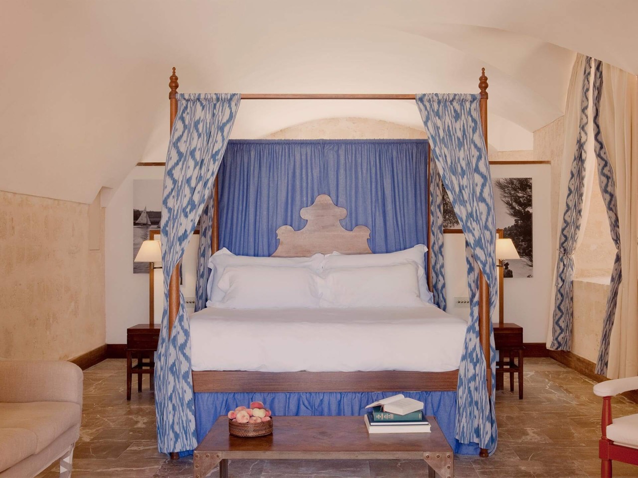 Suite at Cap Rocat with a blue four poster canopy bed under a vaulted stone ceiling