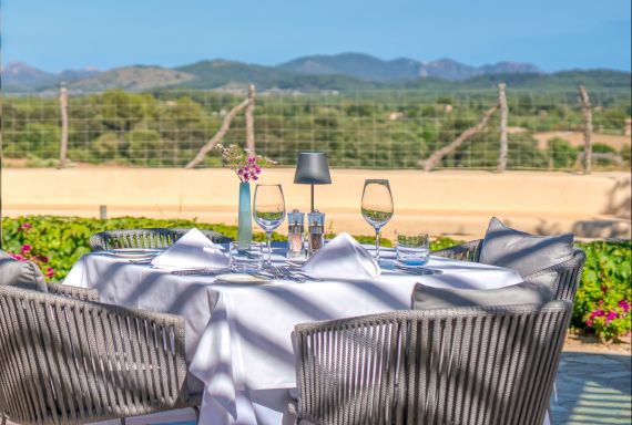 Restaurant terrace table set for dining with hills in the background