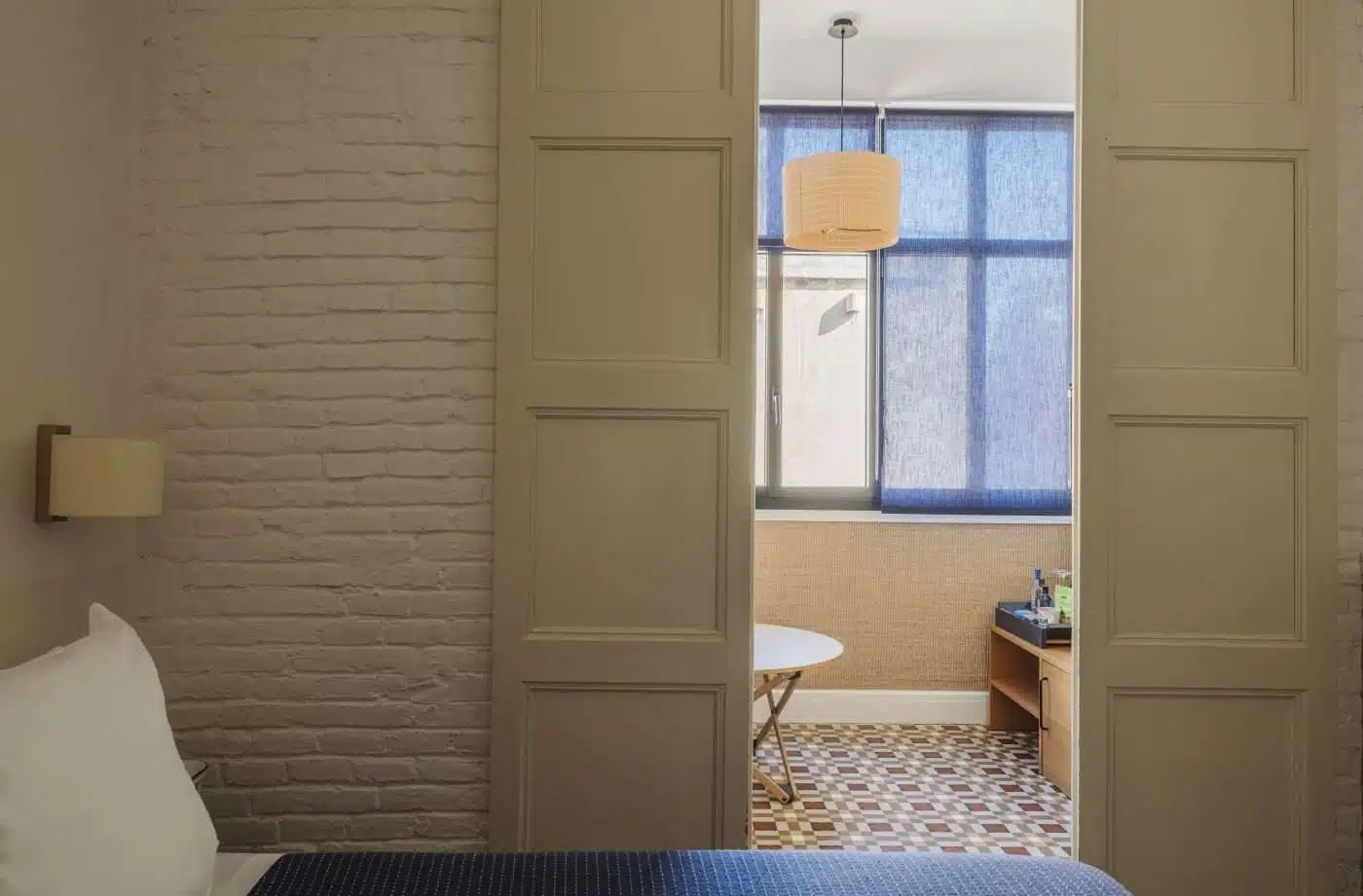 Guest room with sliding doors to a seating nook and a patterned tile floor