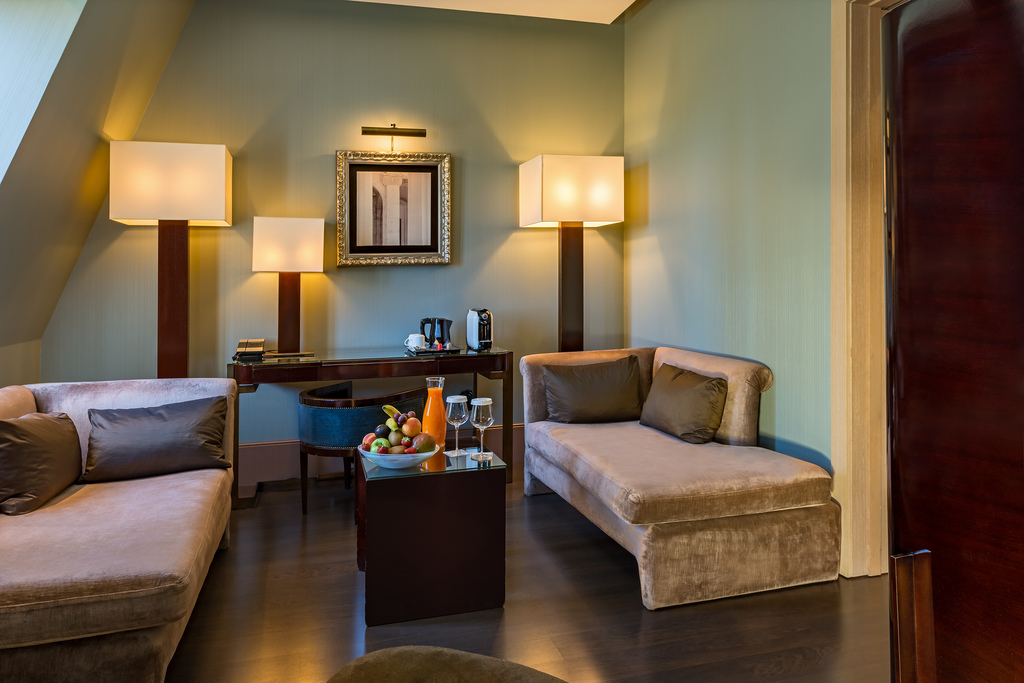 Junior suite seating area with two sofas and a work desk