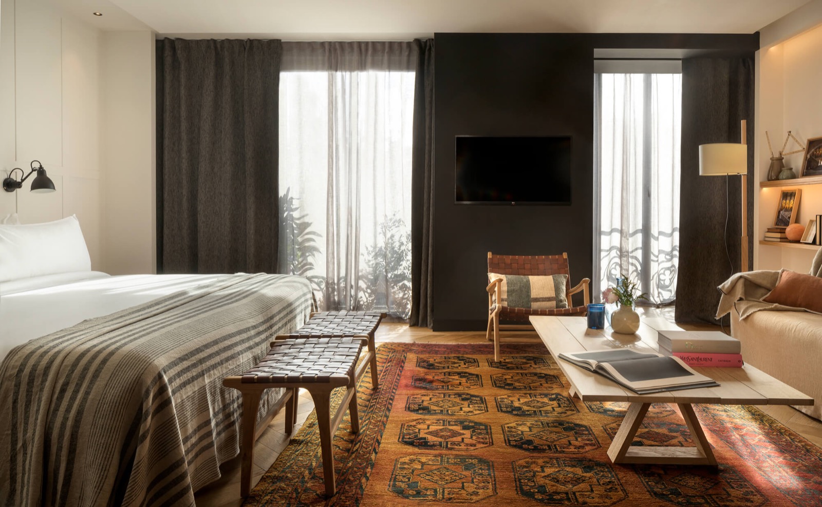 Suite bedroom and lounge with a patterned rug and leather stools