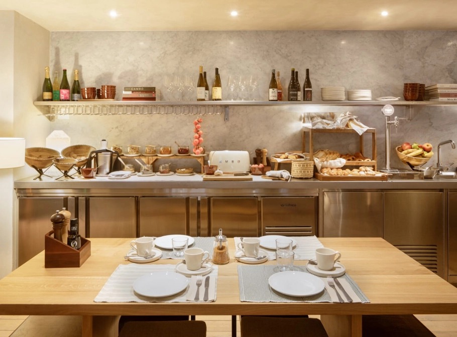 Breakfast buffet counter with bread baskets, fruit and place settings