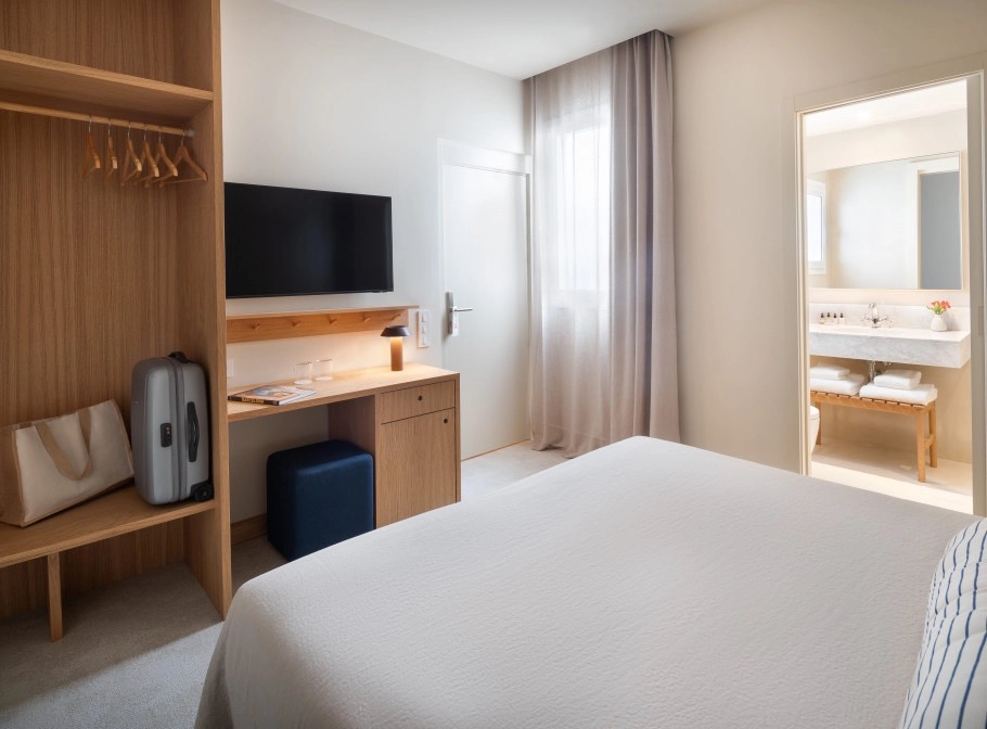 Cozy room with a wardrobe, luggage bench and a view into the ensuite