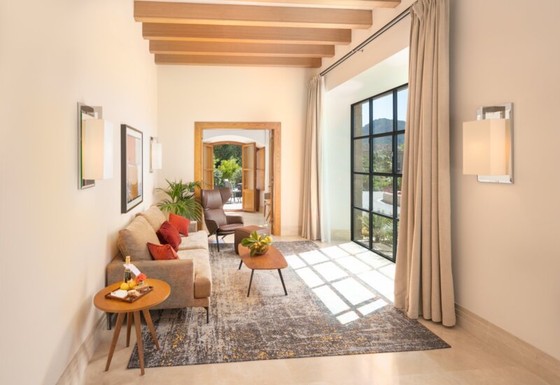 Suite living room at Castell Son Claret with beamed ceiling and mountain view