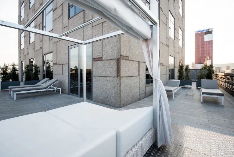 Suite private terrace with a daybed and the city skyline