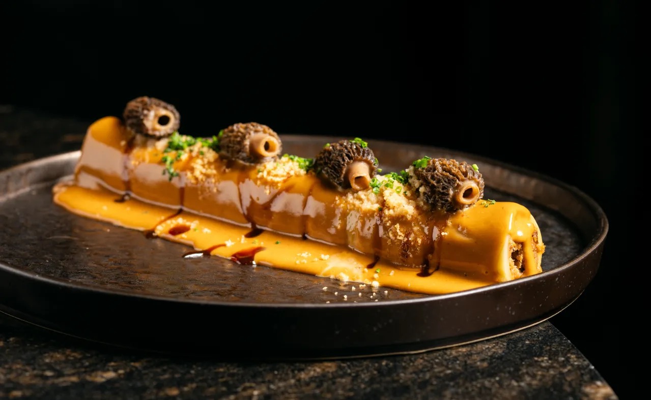 Plated restaurant dish with a morel mushroom garnish