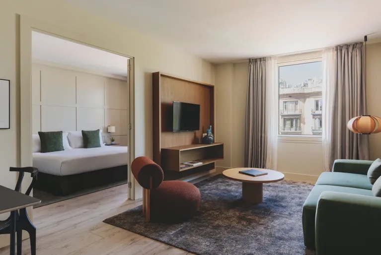 Suite living area with a sofa and a view into the bedroom