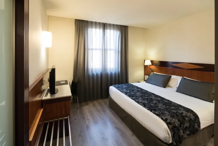 Double room with a wood headboard and a desk