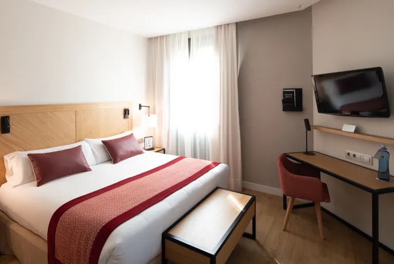 Premium room with burgundy bedding and a wall-mounted TV