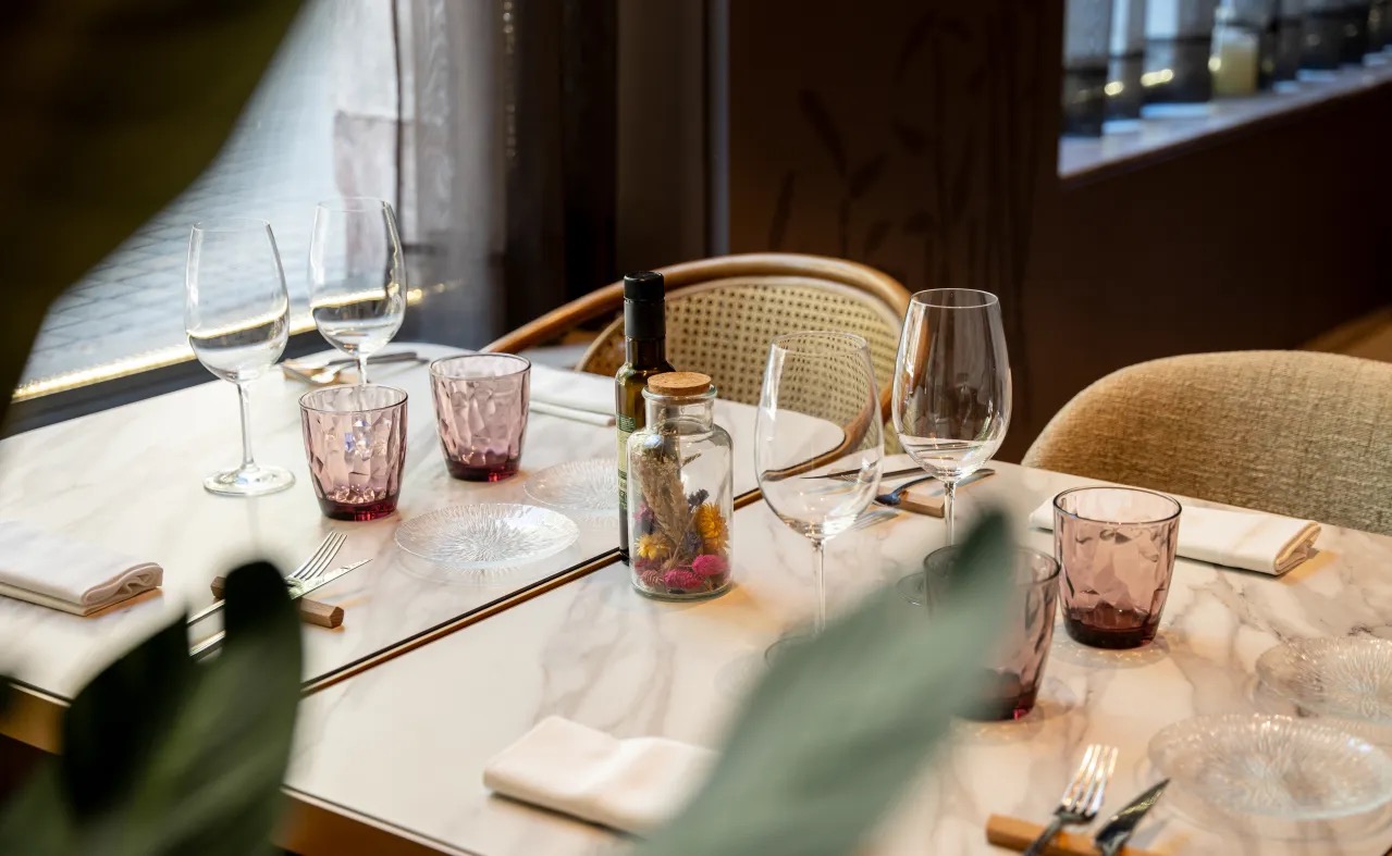 Restaurant table set with wine glasses on a marble tabletop