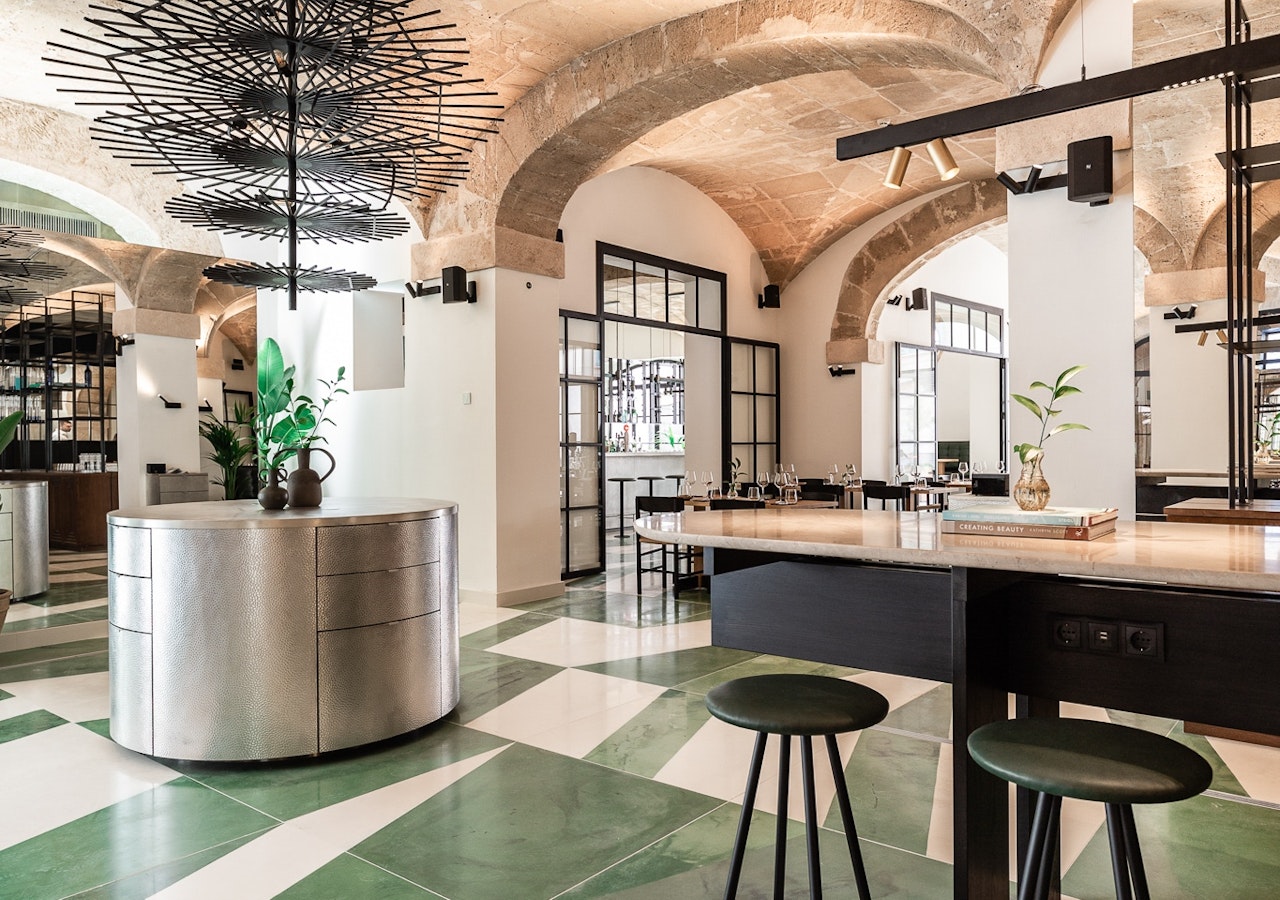 Restaurant and lounge area under stone vaulted ceilings with green and white tiled floor
