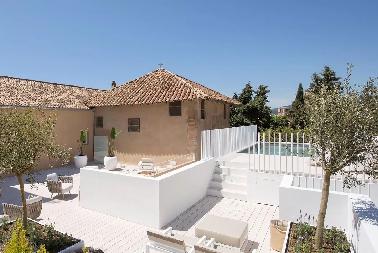 Rooftop terrace and pool at Convent de la Missio with the former convent chapel behind