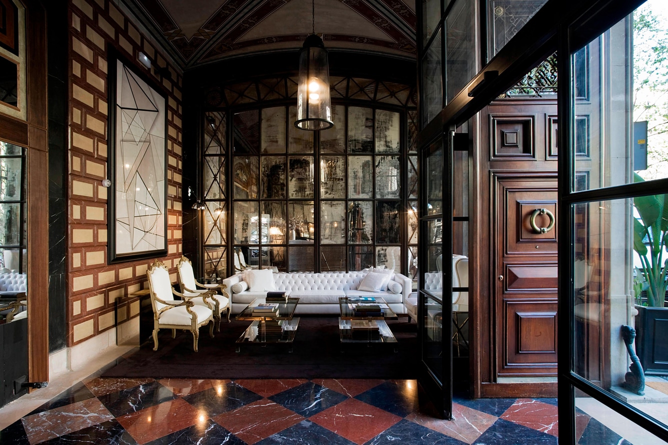 Lobby seating with a white Chesterfield sofa, gilt armchairs and a checkered marble floor