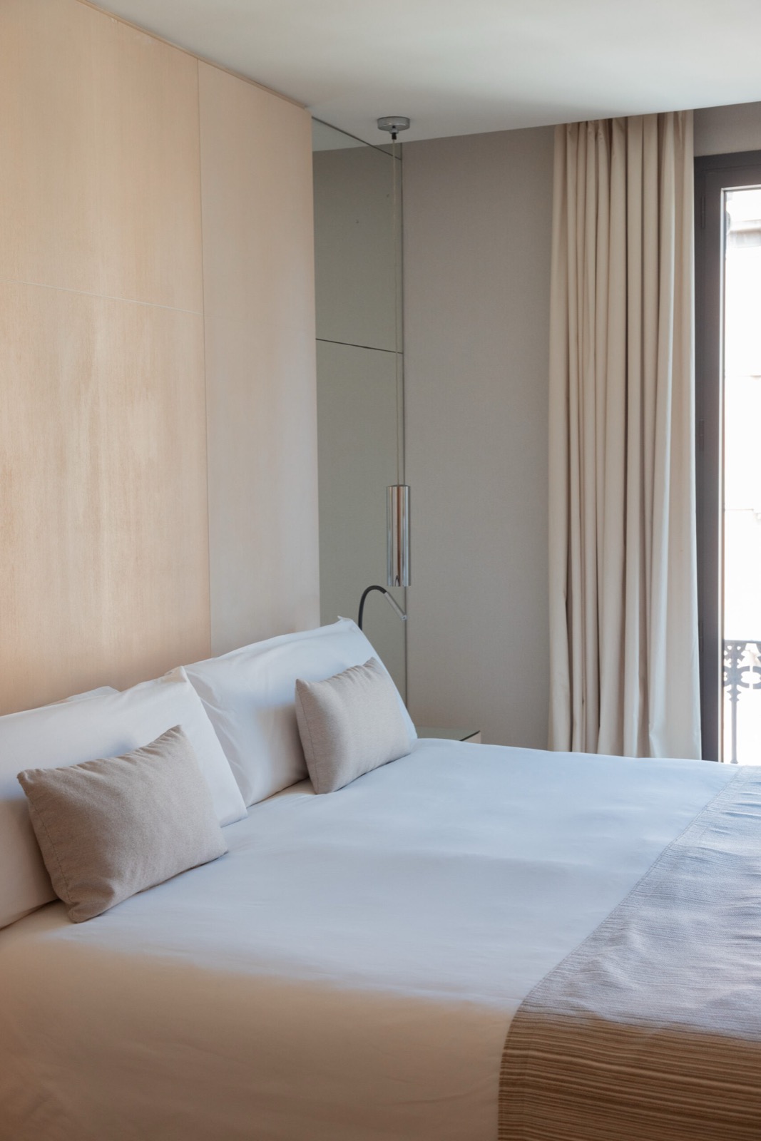 Guest room with a king bed and a wood-paneled headboard wall