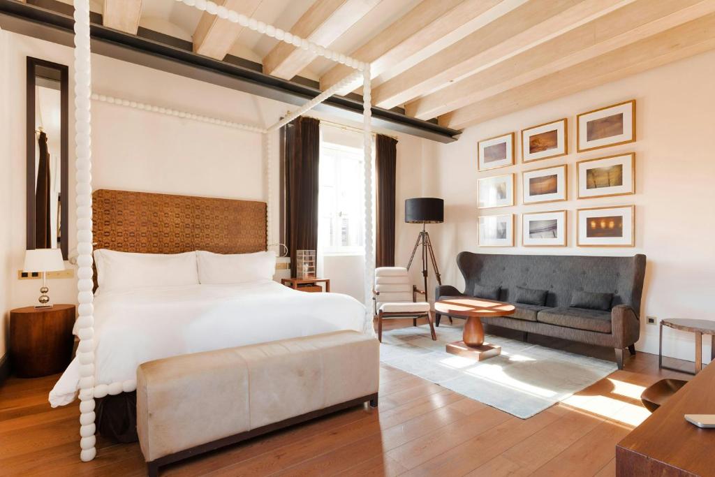Room at Hotel DO: Plaça Reial with a four-poster bed, a sitting area and oak floors beneath beamed ceilings