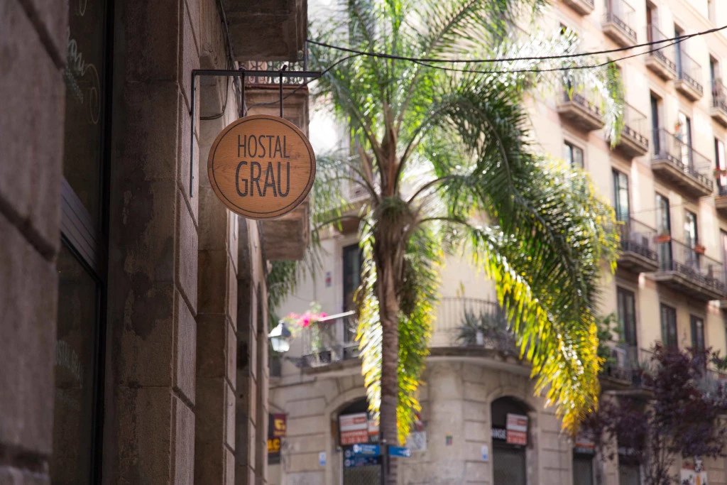 Carrer de les Ramelleres outside Eco Boutique Hostal Grau, with the round 'Hostal Grau' sign hanging over the street