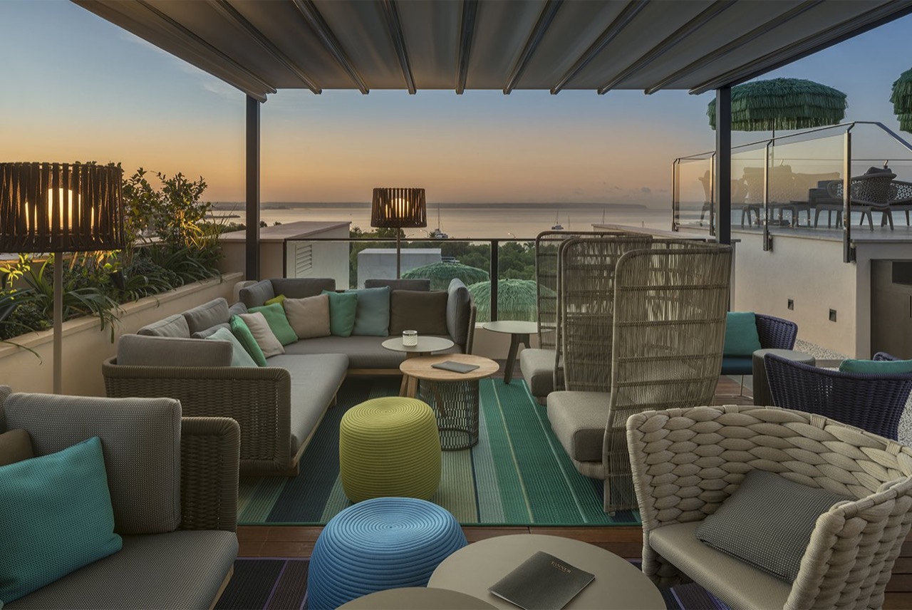 Rooftop bar lounge seating at El Llorenc at sunset, with the bay of Palma in the background