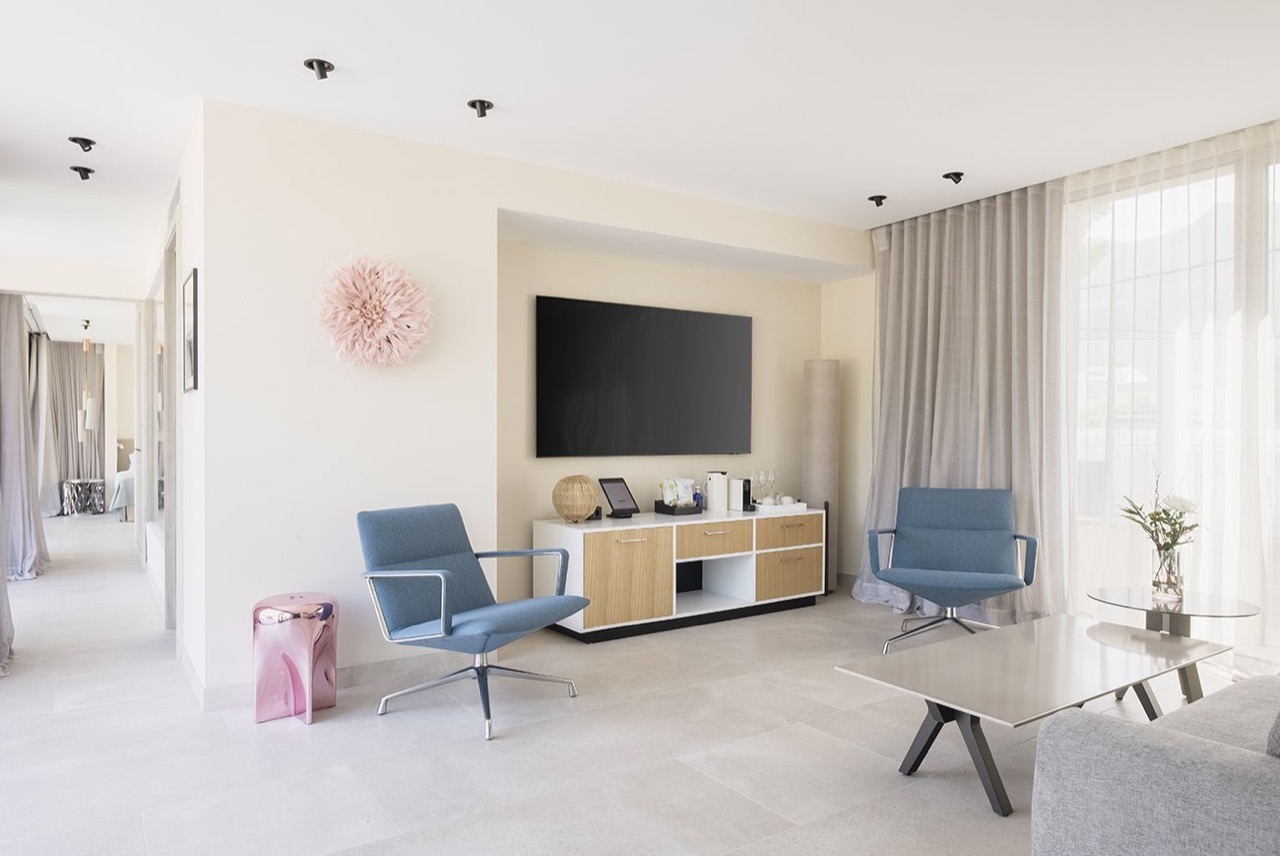 Suite living area with blue swivel chairs and a large window